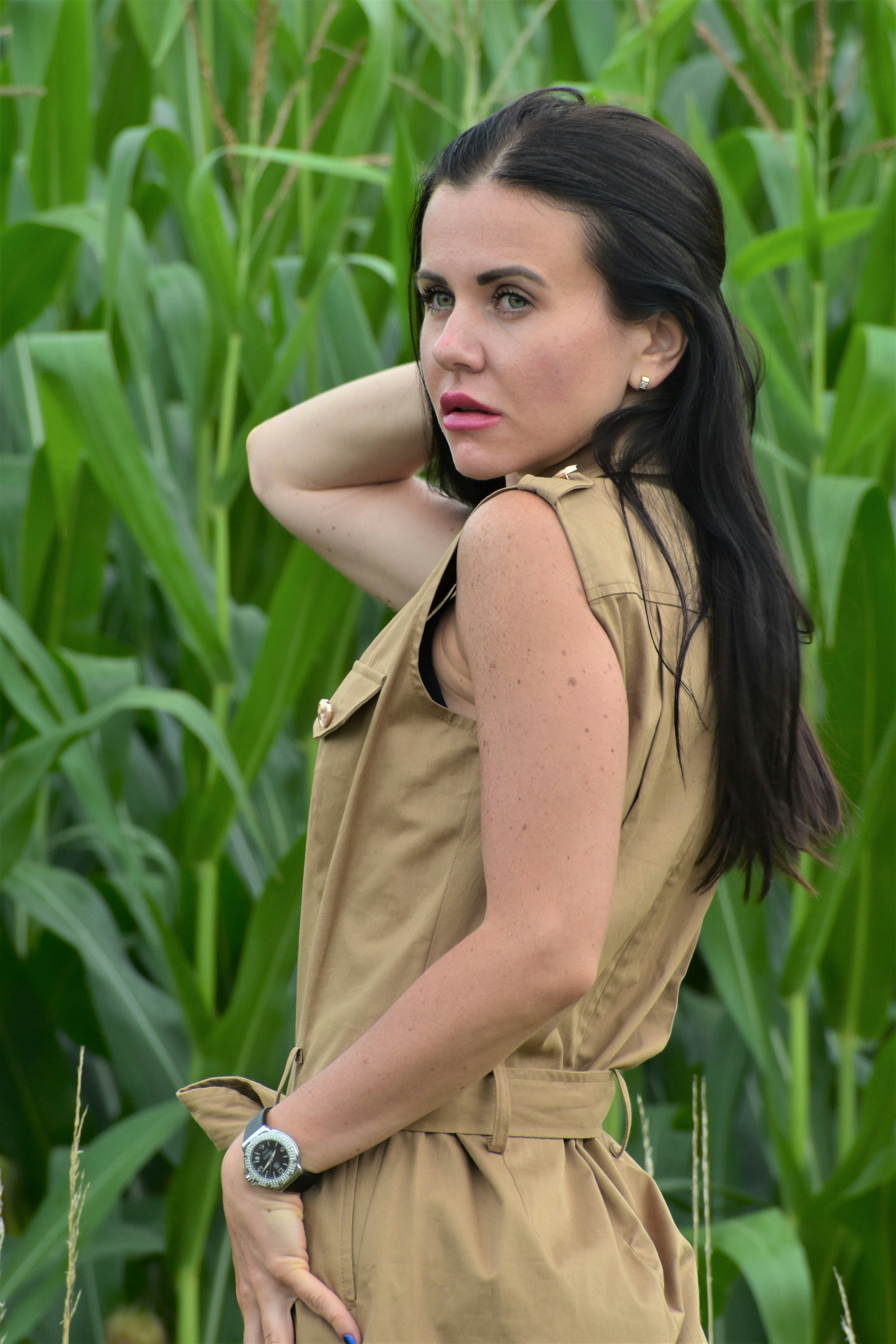 a woman standing in front of a corn field