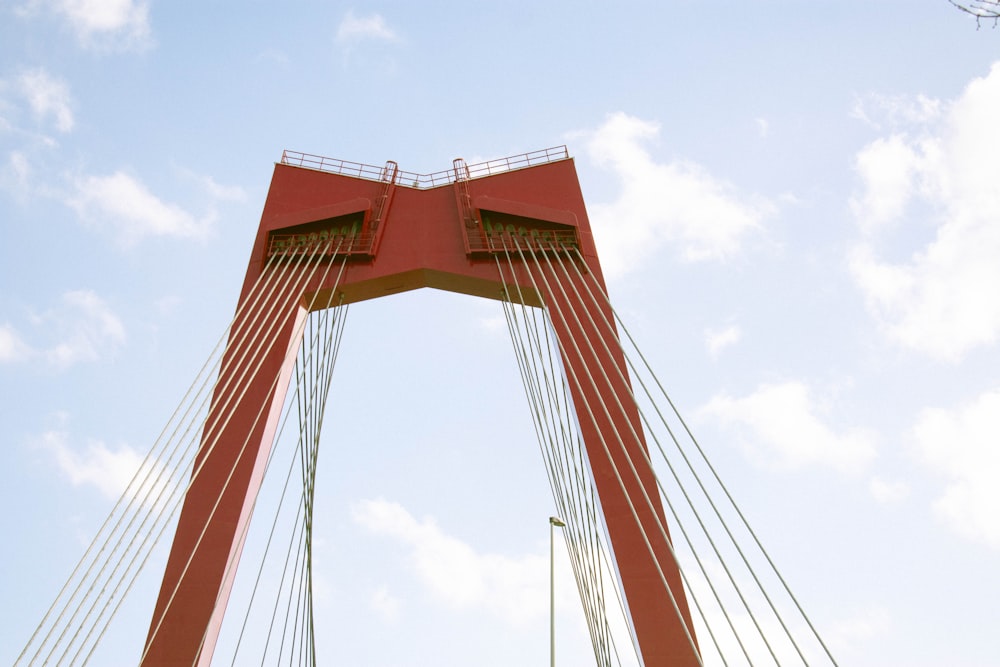 a very tall red bridge with a sky background