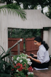 a woman sitting on the ground looking at her cell phone