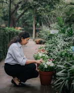 A gardener tending to a well-maintained garden with flowers and greenery.