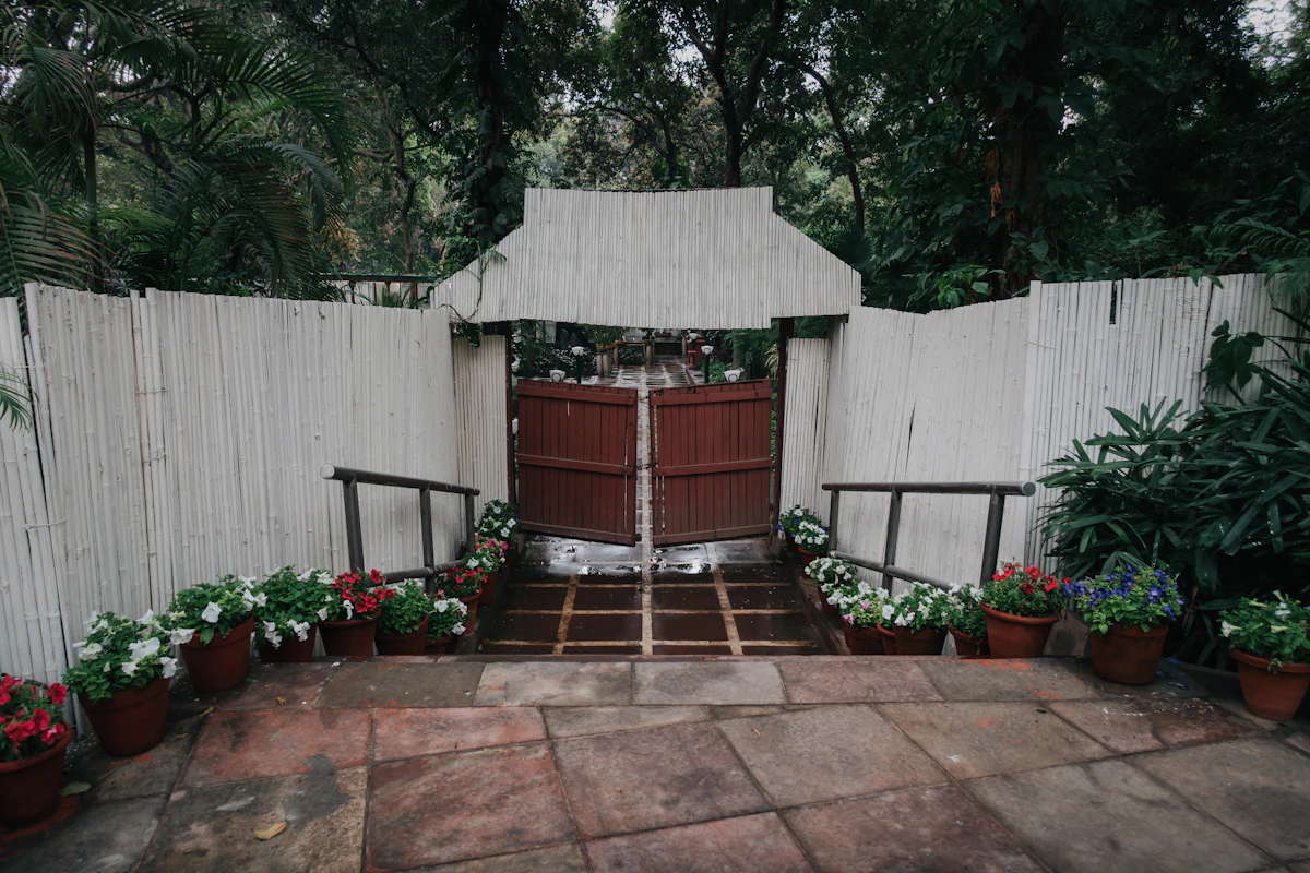 White fence with a gate and potted plants
