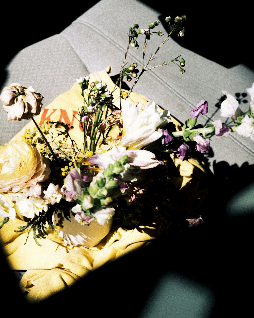a bouquet of flowers sitting on top of a yellow cloth