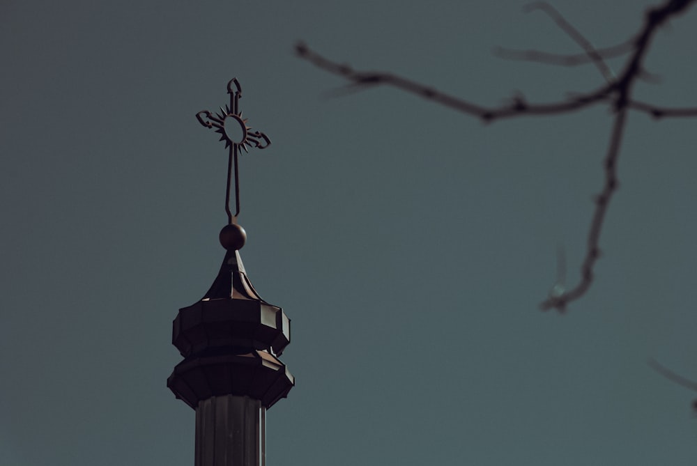 a clock tower with a weather vane on top of it