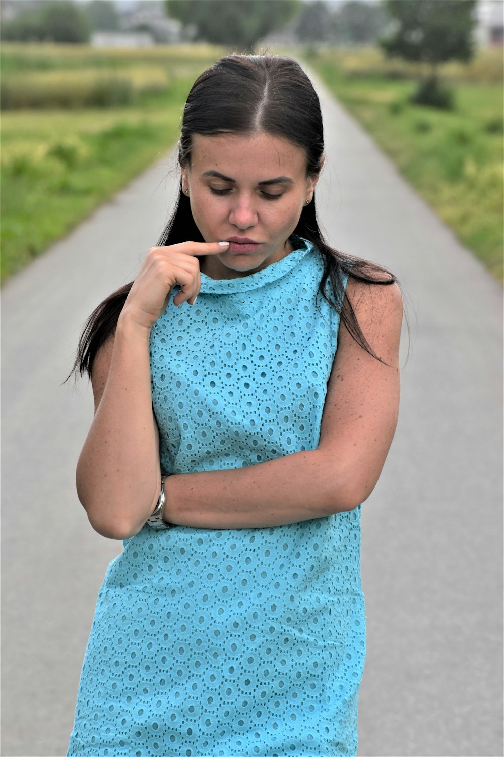 Una mujer con un vestido azul sosteniendo un cigarrillo