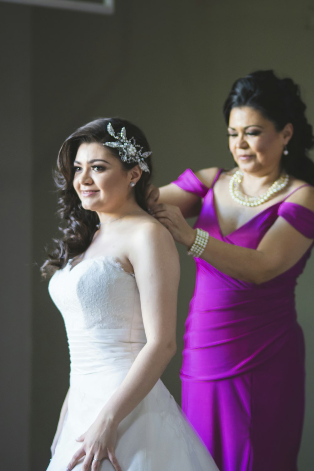 a woman in a purple dress getting ready for a wedding