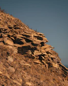 A group of researchers examining rock formations on a sunny hillside.
