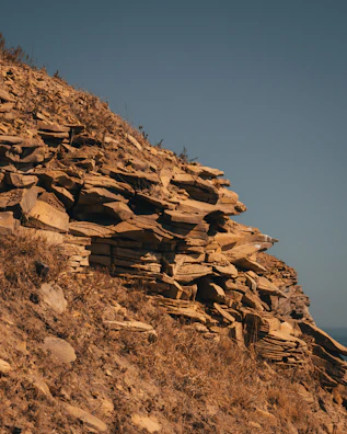 A group of researchers examining rock formations on a sunny hillside.
