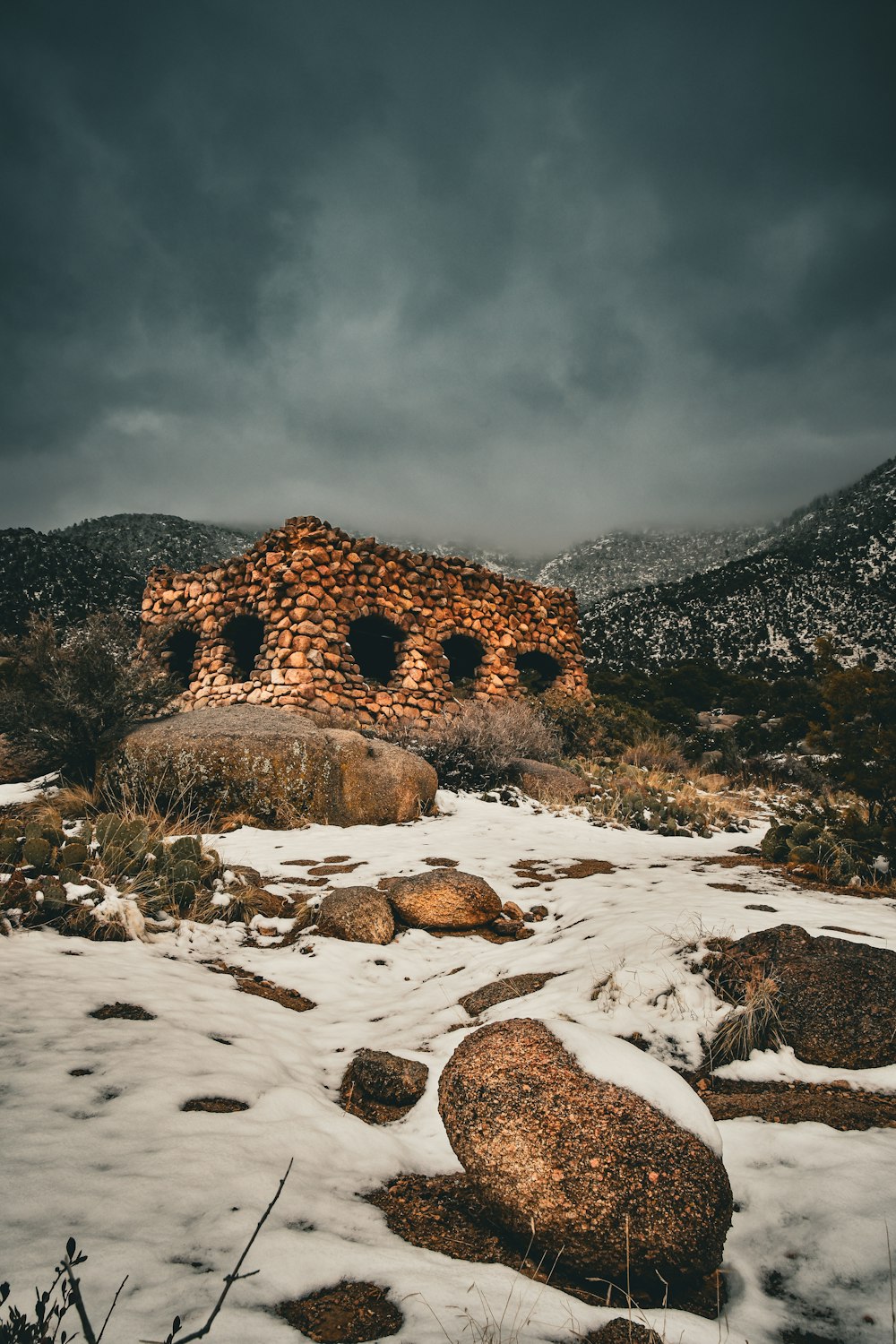 a stone building sitting on top of a snow covered field