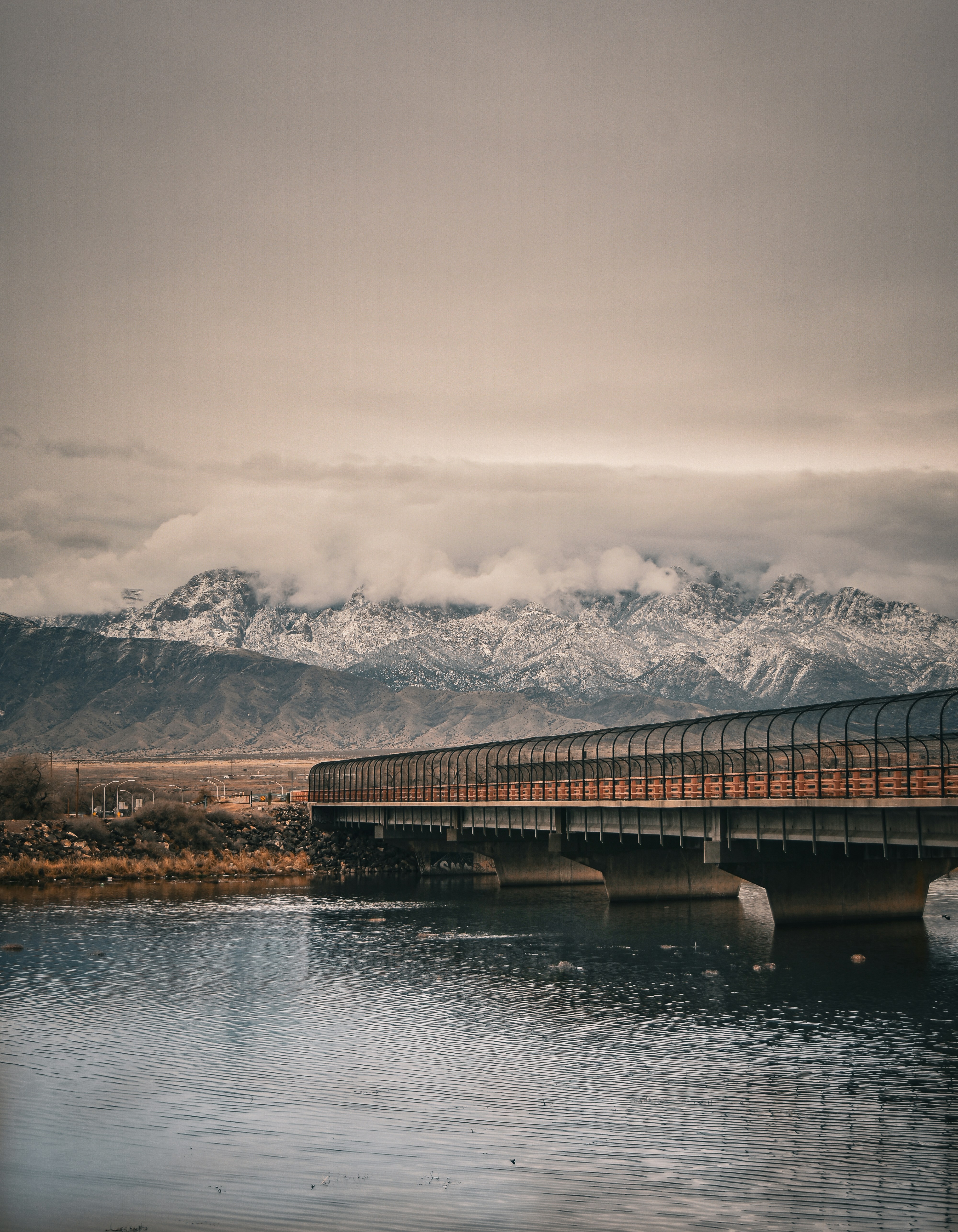 a bridge over a body of water with mountains in the background