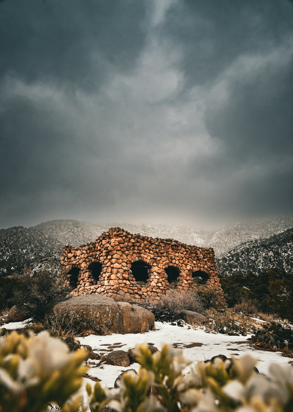 a stone building sitting on top of a snow covered field