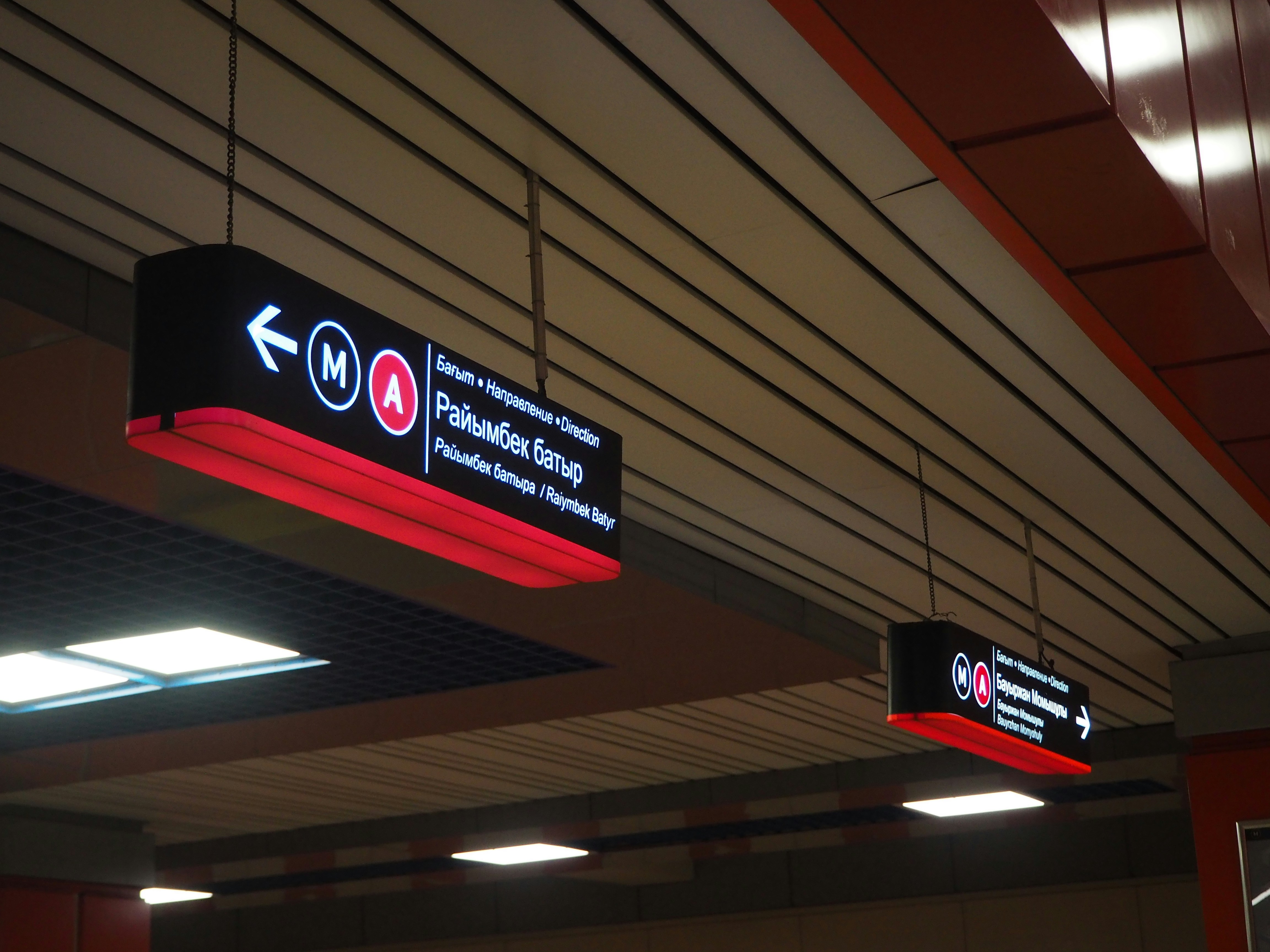 A couple of signs hanging from the ceiling of a building photo – Free ...