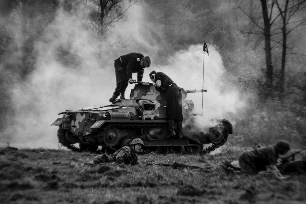 a couple of men standing on top of a tank