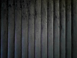 A series of vertically aligned, dark-colored textured panels creating a uniform pattern.