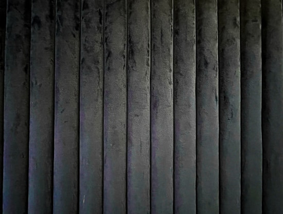 A series of vertically aligned, dark-colored textured panels creating a uniform pattern.