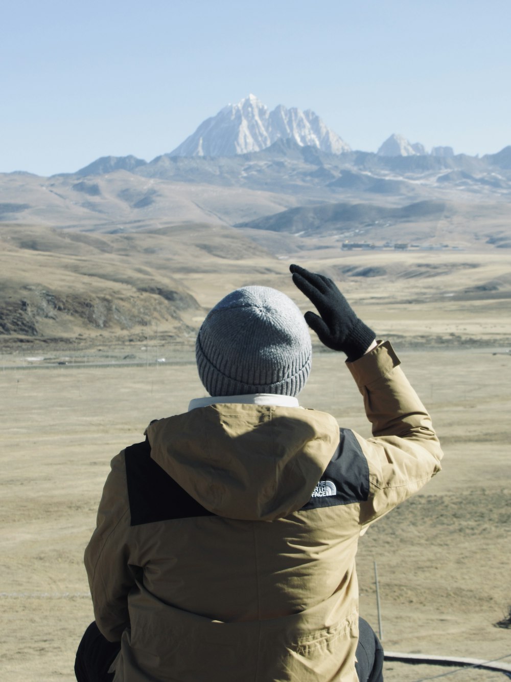 a person sitting on a bench looking at a mountain