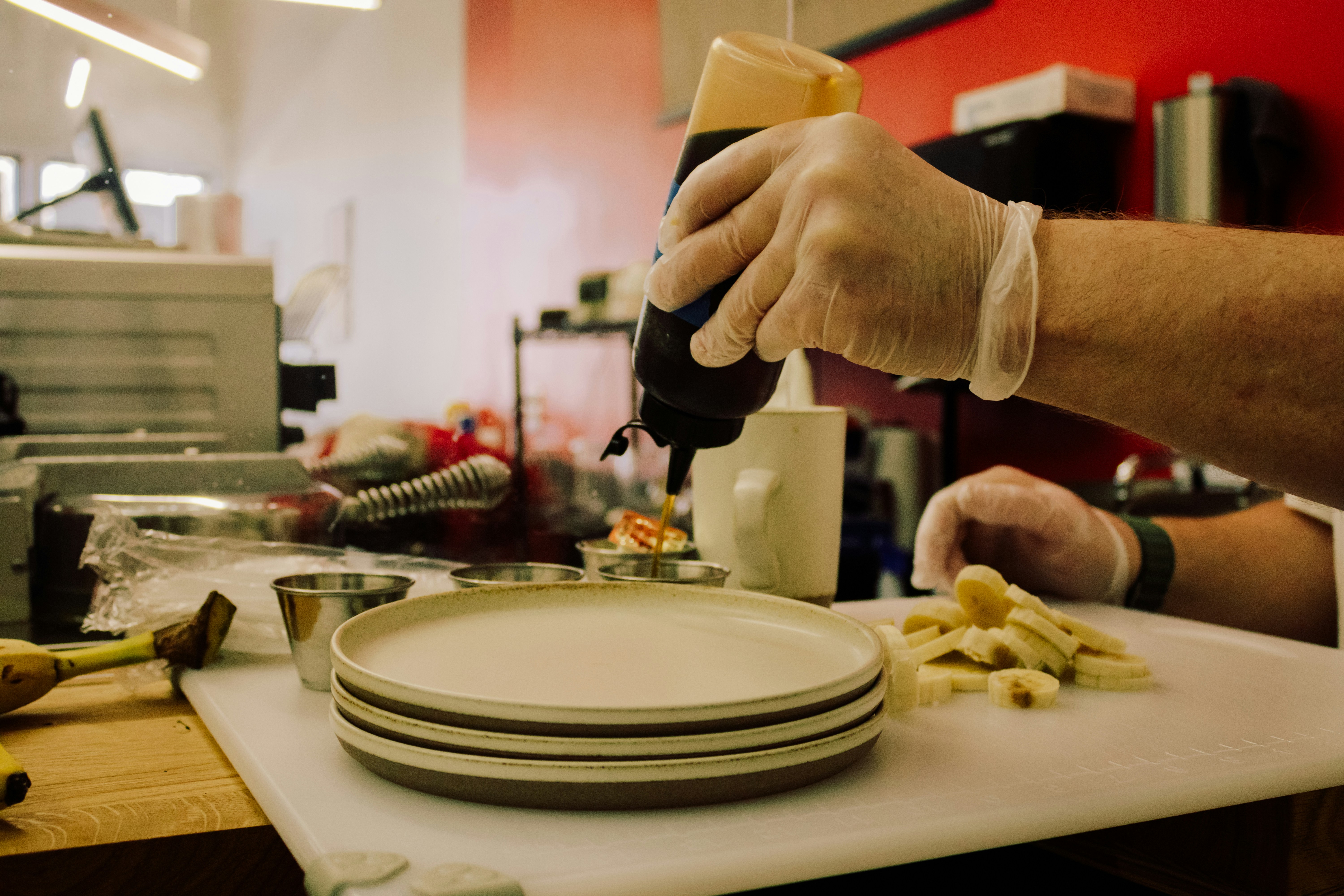 a person pouring something into a plate on a counter