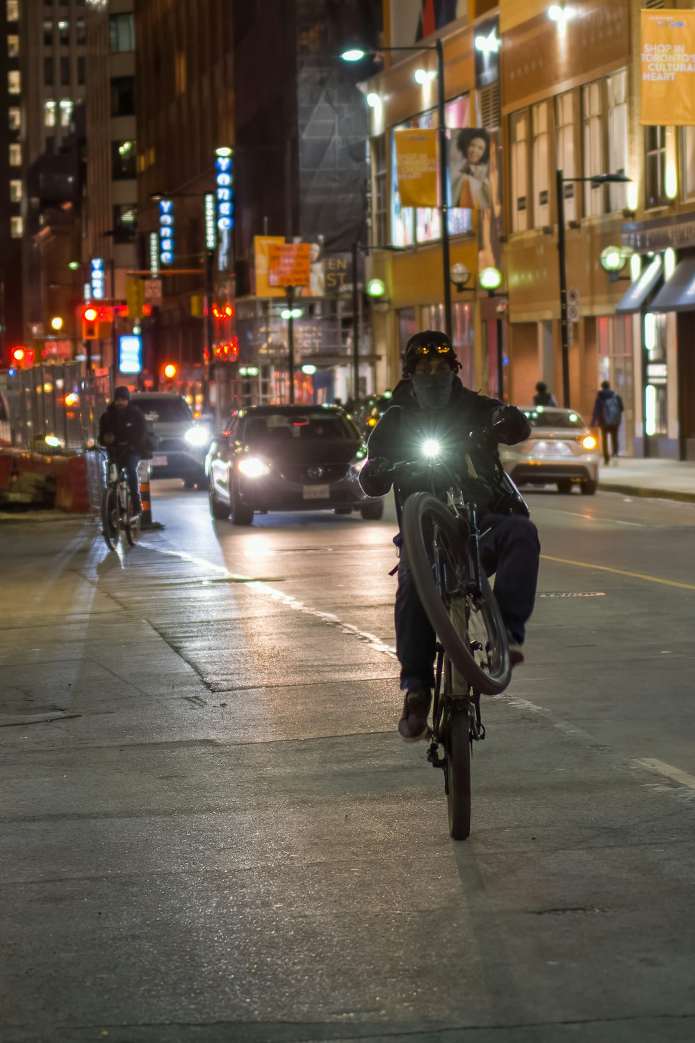 a man riding a bike down a street at night