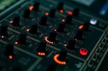 a close up of a sound board with many knobs