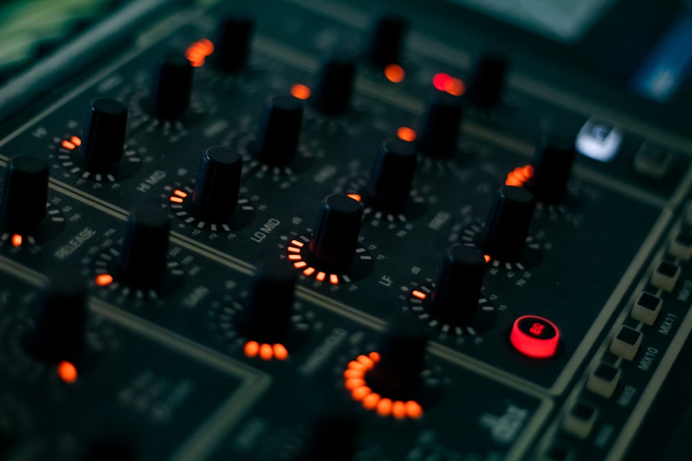 a close up of a sound board with many knobs