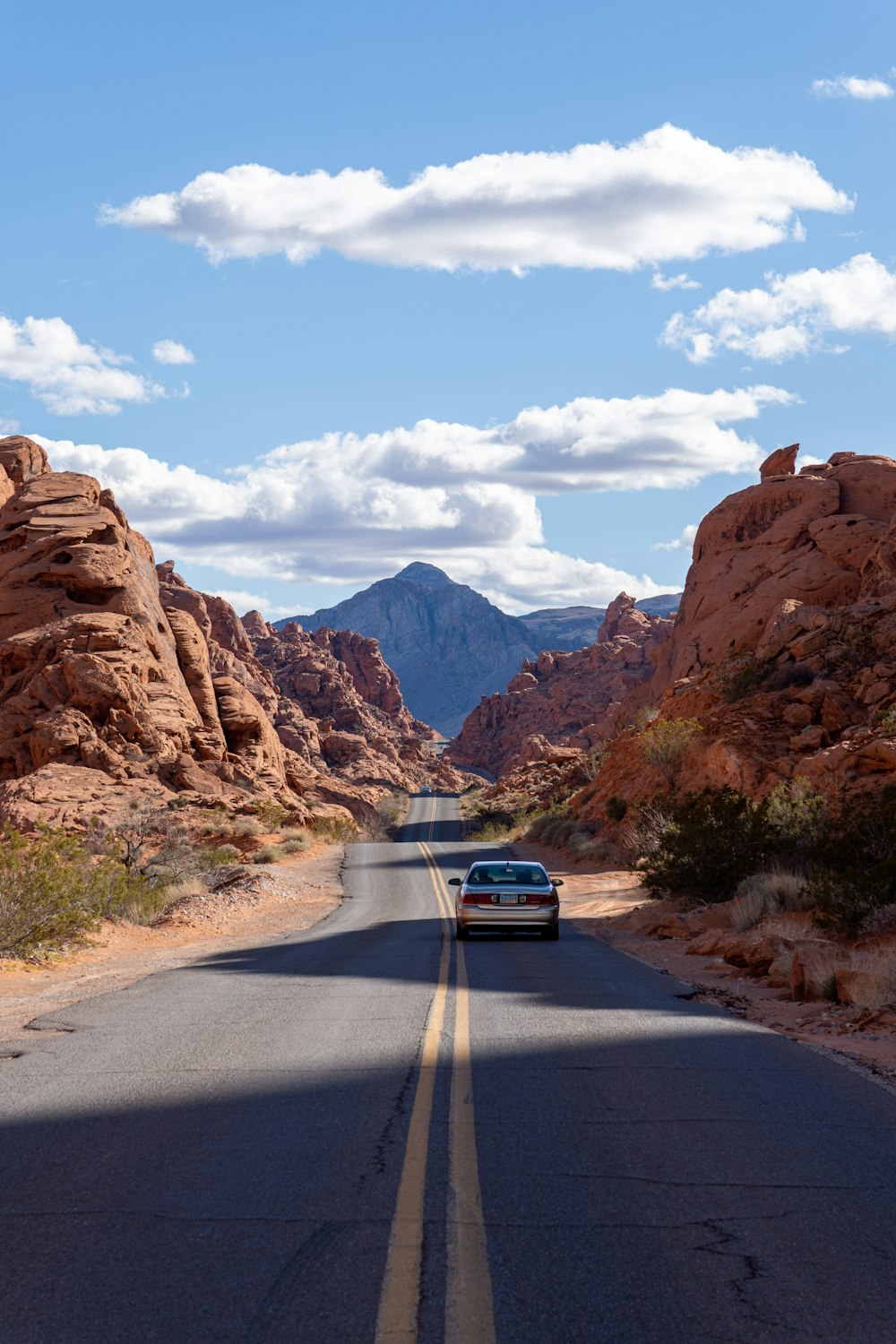 a car driving down a road in the desert