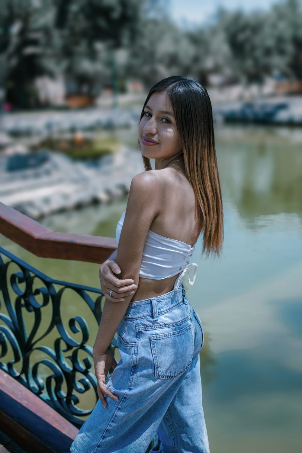 a woman standing on a bridge next to a body of water