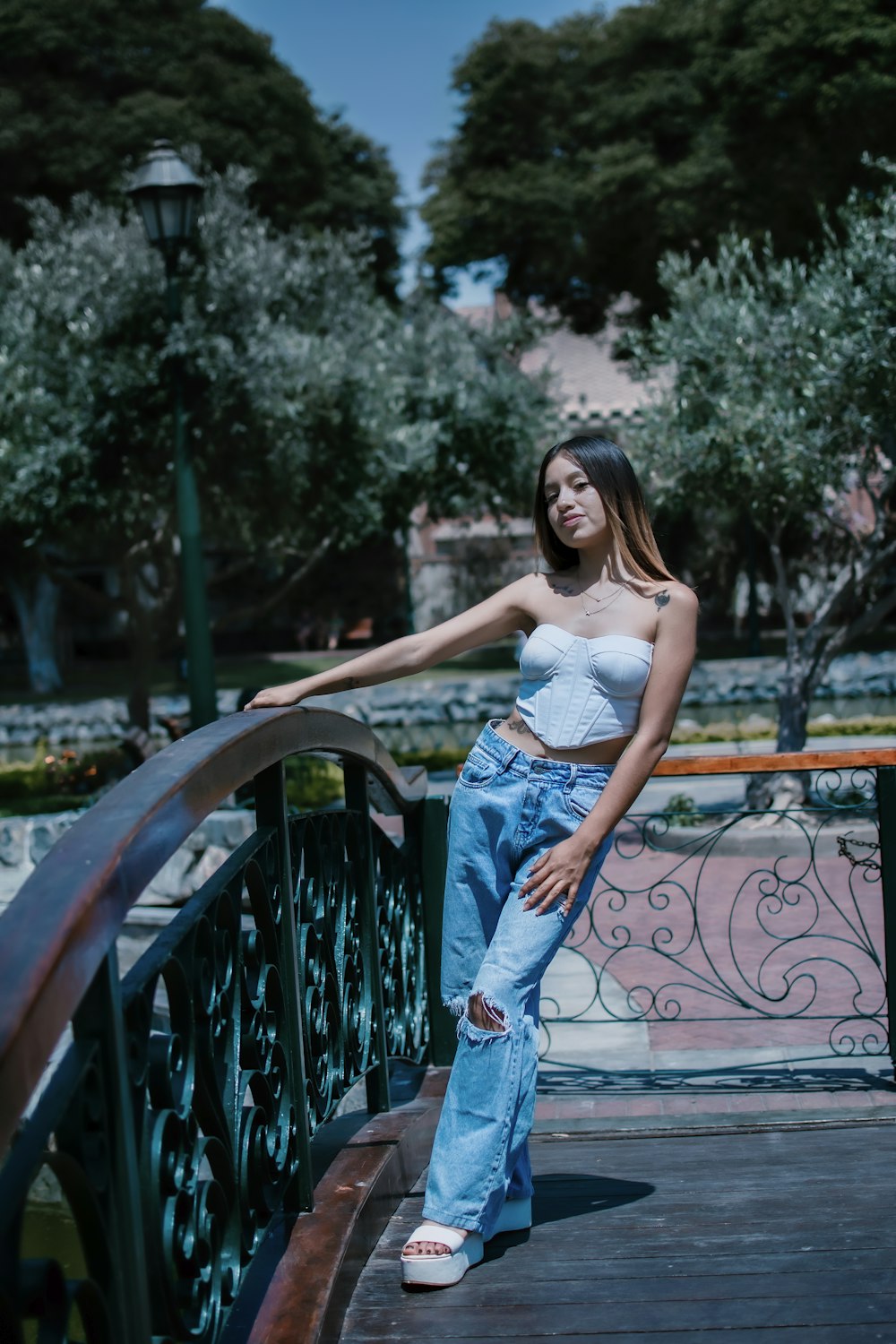 a woman standing on a bridge with her hand on her hip