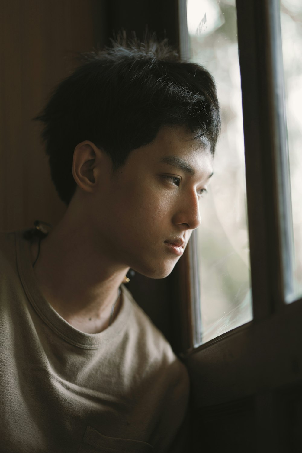 a man looking out of a window with a serious look on his face