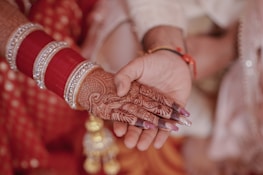 Hands gently holding a printed nikahnama certificate with elegant sage green and beige tones.