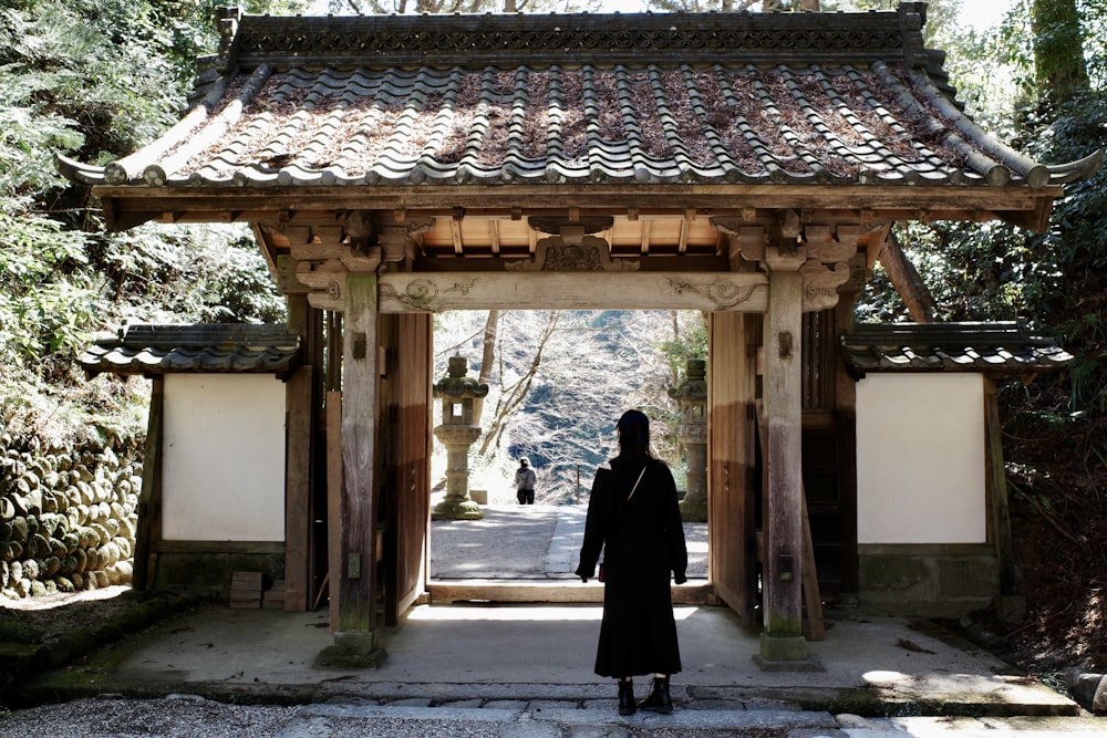 a woman standing in front of a wooden structure