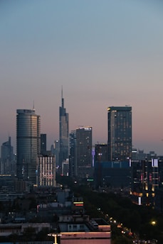 A vibrant city skyline at dusk, showcasing modern buildings and colorful lights.