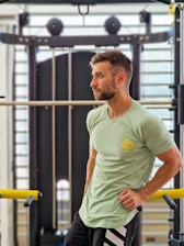 a man standing in a gym with his hands on his hips
