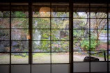 A serene zen garden corner visible through a studio window, showcasing stones and greenery.