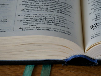 An open retro book with yellowed pages and a pastel blue cover on a wooden table.