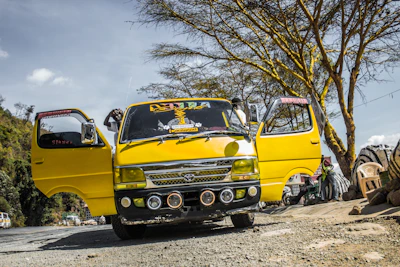 A sleek Toyota Coaster bus parked ready for a group trip under clear skies.