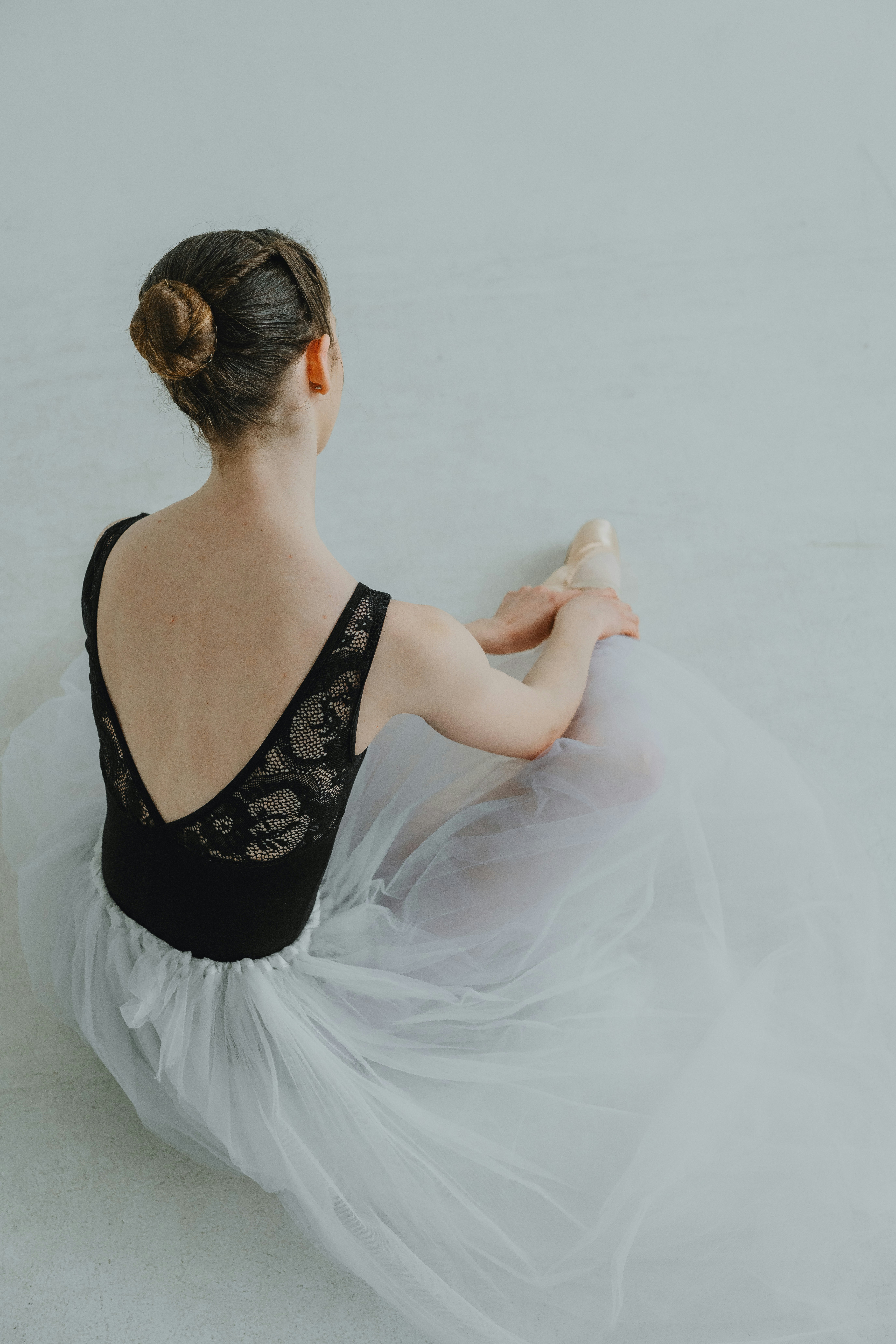 Une femme assise par terre dans une robe blanche