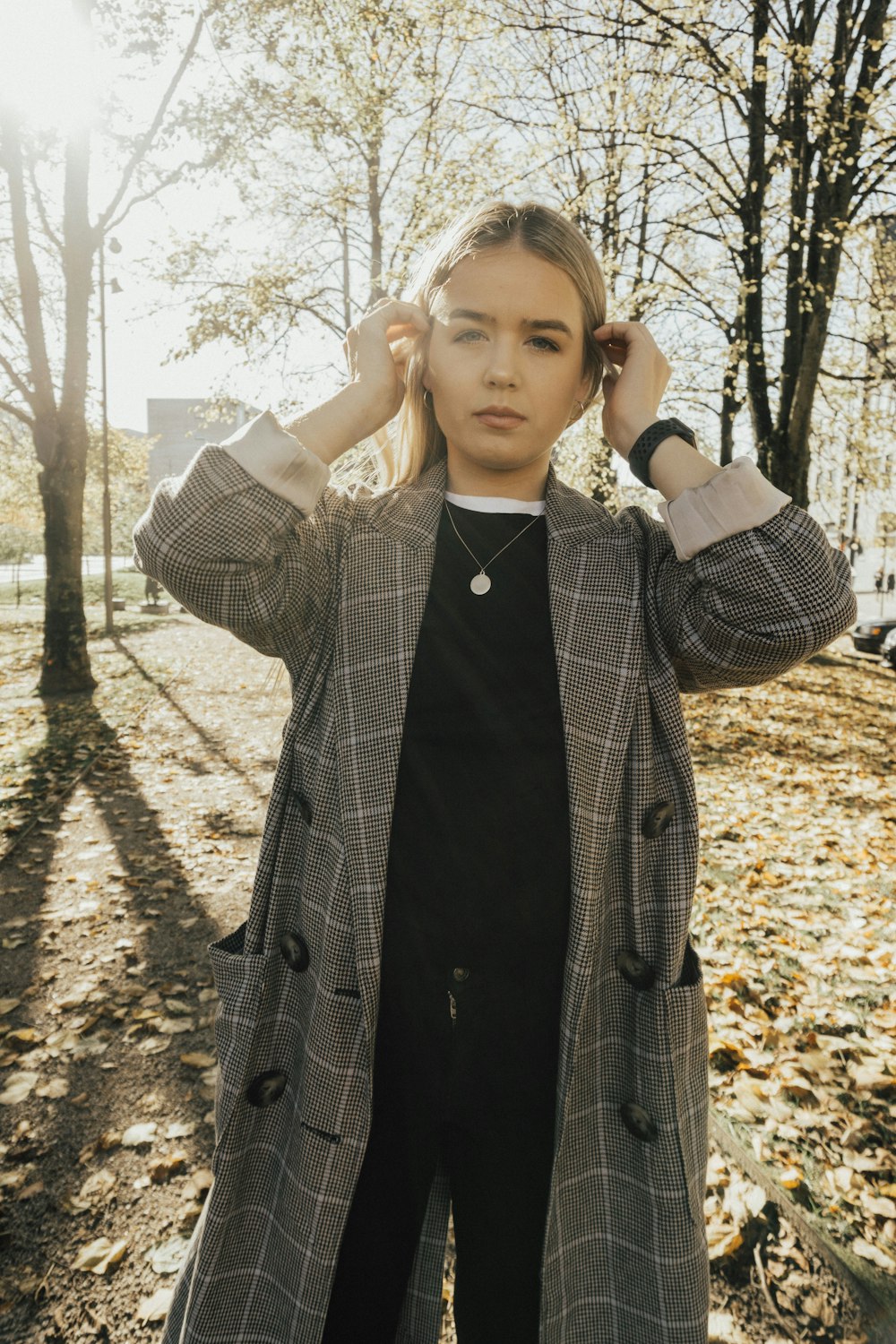 a woman standing in the woods with her hands on her head