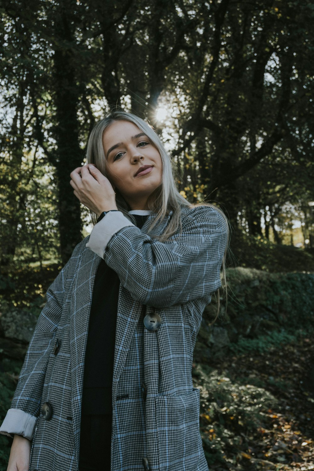 a woman standing in front of some trees