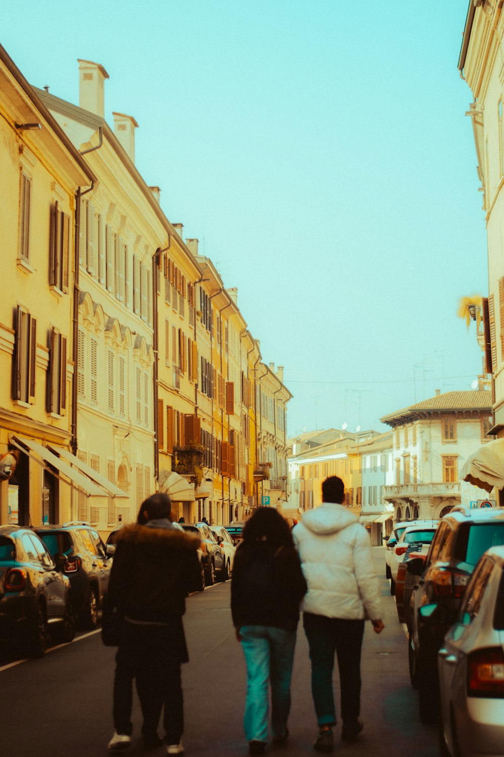 a group of people walking down a street next to tall buildings