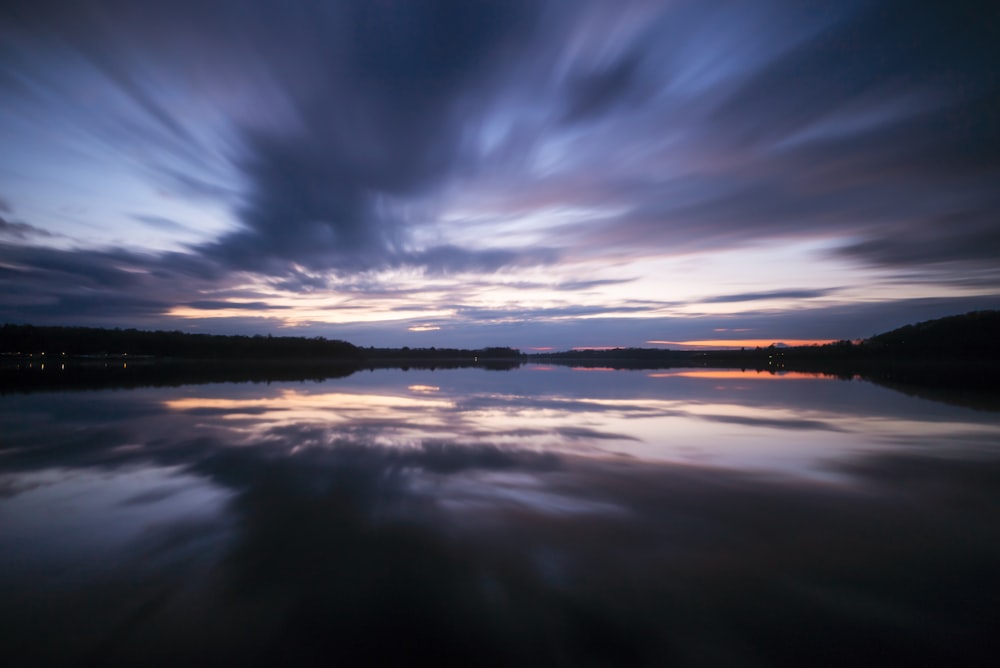 a body of water with clouds in the sky