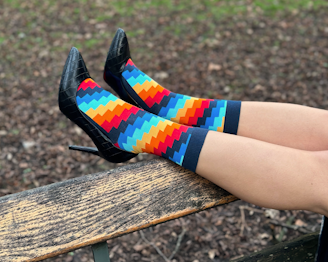 a person wearing colorful socks sitting on a bench