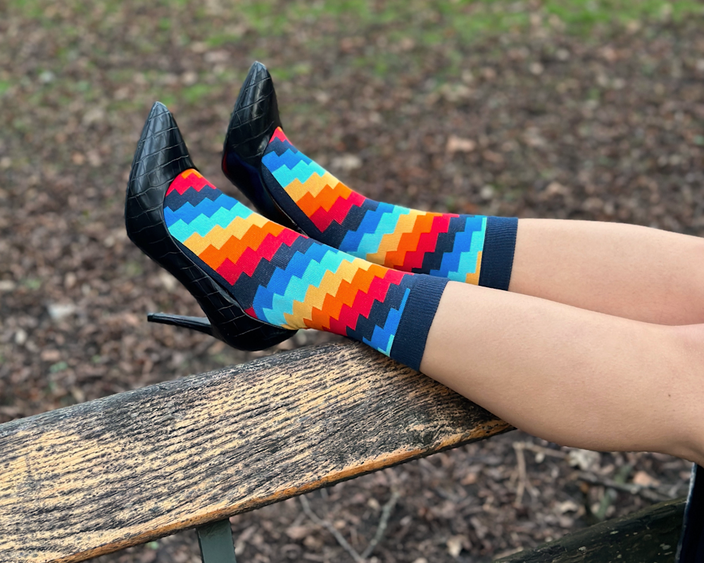 a person wearing colorful socks sitting on a bench