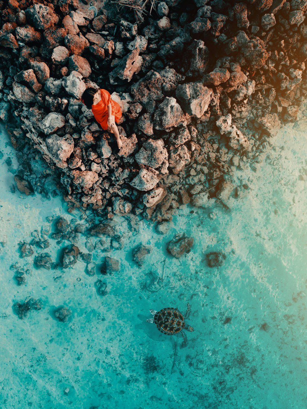 an aerial view of rocks and water in the ocean