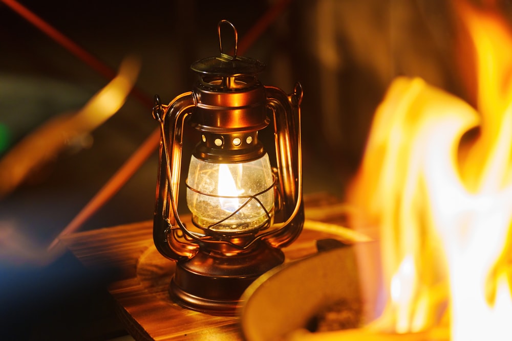 a burning lantern sitting on top of a wooden table
