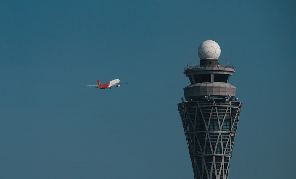 um avião está voando por uma torre de controle