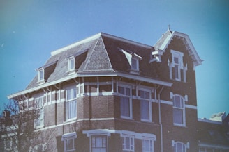 A warm, inviting photo of the century-old house bathed in soft morning light, showing its charming facade and aged wooden details.