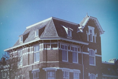 A warm, inviting photo of the century-old house bathed in soft morning light, showing its charming facade and aged wooden details.