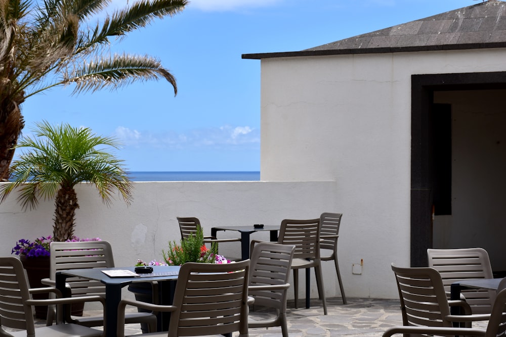 a patio with a table and chairs and a view of the ocean