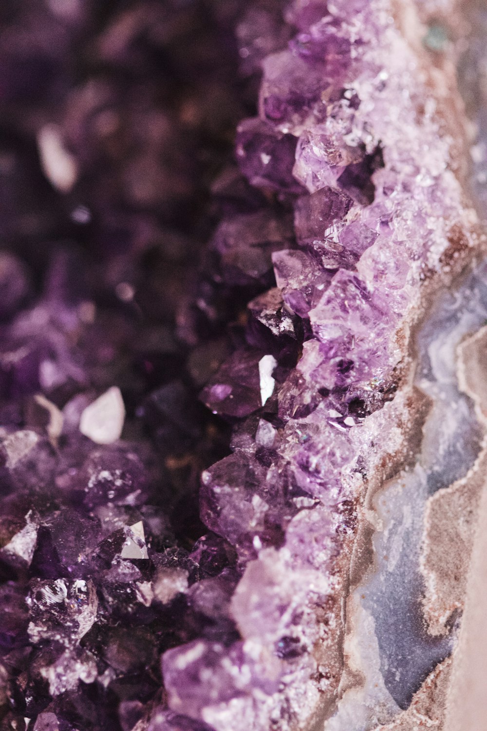 Nahaufnahme eines Felsens mit violetten Kristallen