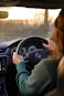 a woman driving a car while holding the steering wheel