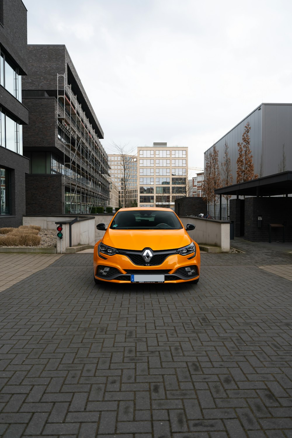 Ein orangefarbenes Auto parkt vor einem Gebäude